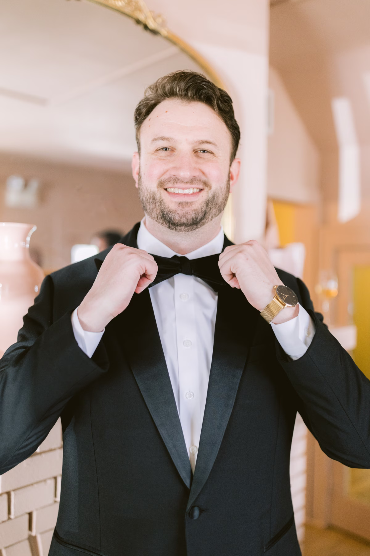 Groom adjusting bow tie in Black Tux formal wear during wedding preparation at St. Pete Shuffleboard Club in Tampa Bay