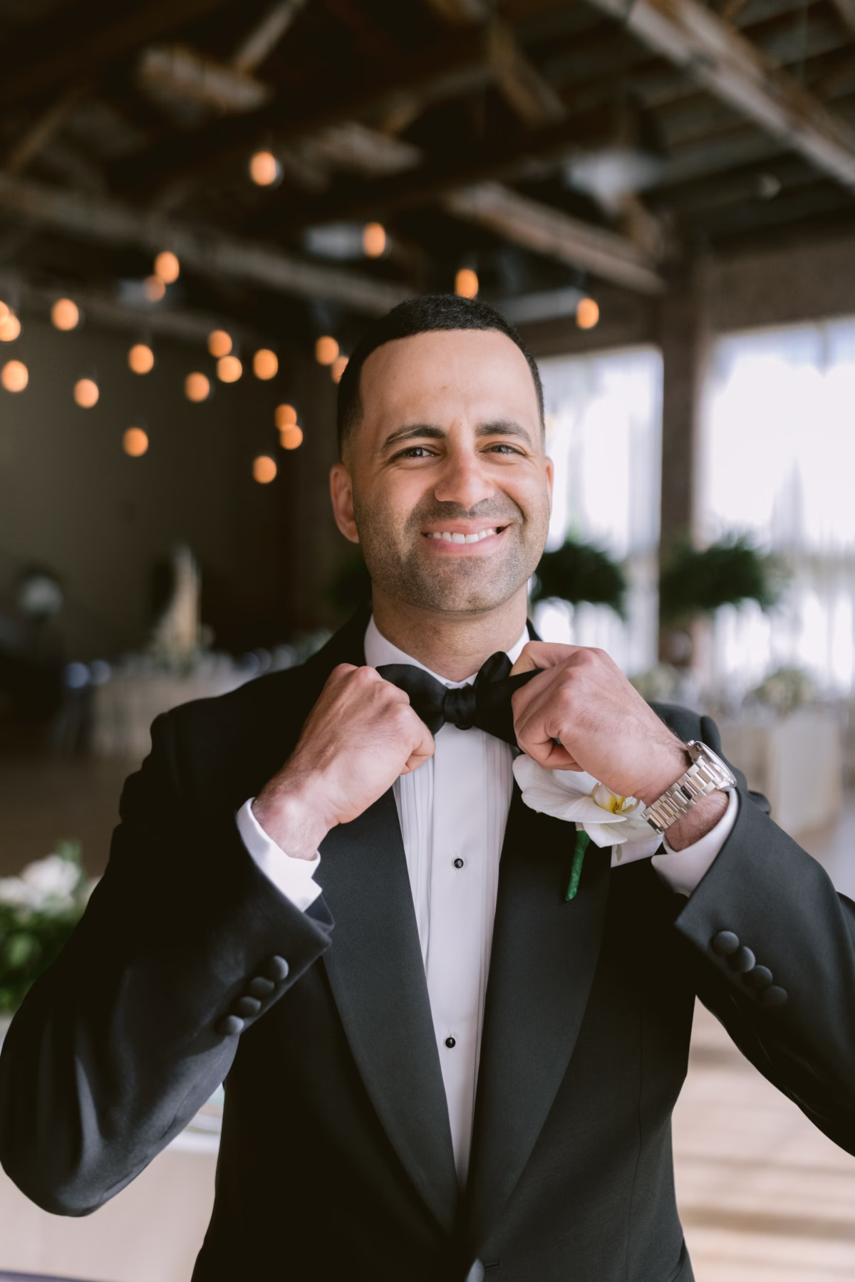 Groom adjusting bow tie while getting ready for Hudson Valley wedding at The Roundhouse Beacon photographed by Ashley Izquierdo Photography