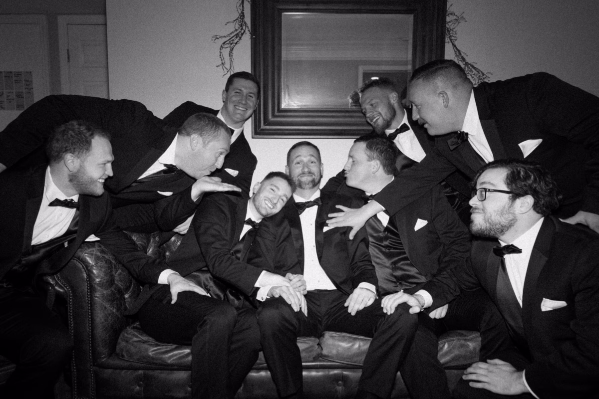 Groomsmen in black tuxedos sharing laughs during wedding preparations at The Vinoy St. Petersburg captured by Ashley Izquierdo Photography