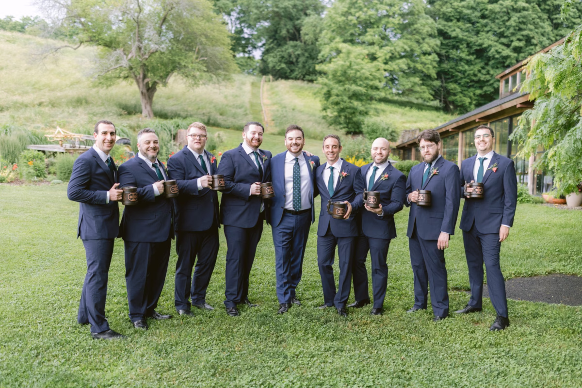 Groomsmen in navy suits holding wooden mugs at Red Maple Vineyard wedding photographed by Ashley Izquierdo Photography