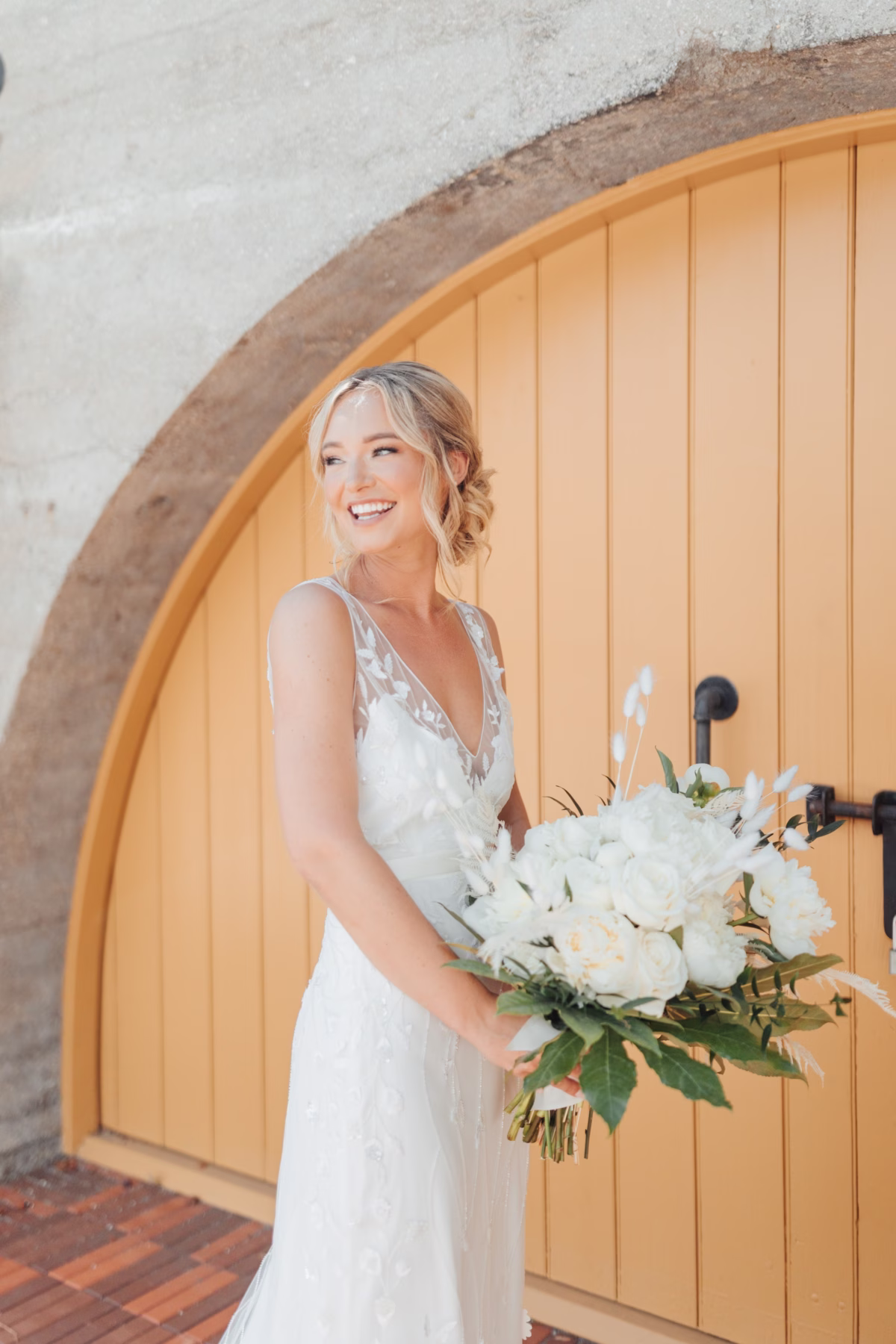 Bride in Alexandra Grecco wedding dress holds white bridal bouquet by Aime Peterson Flowers at historic Lightner Museum wedding in St Augustine