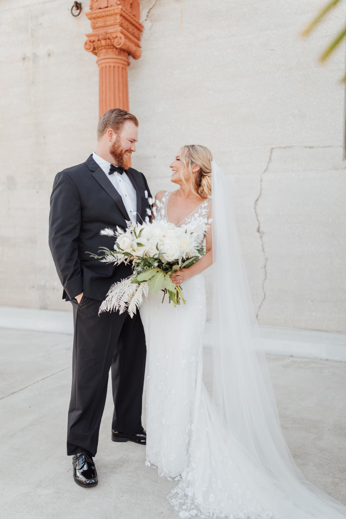 Bride and groom with white floral bouquet by Aime Peterson Flowers at historic Lightner Museum wedding in St. Augustine