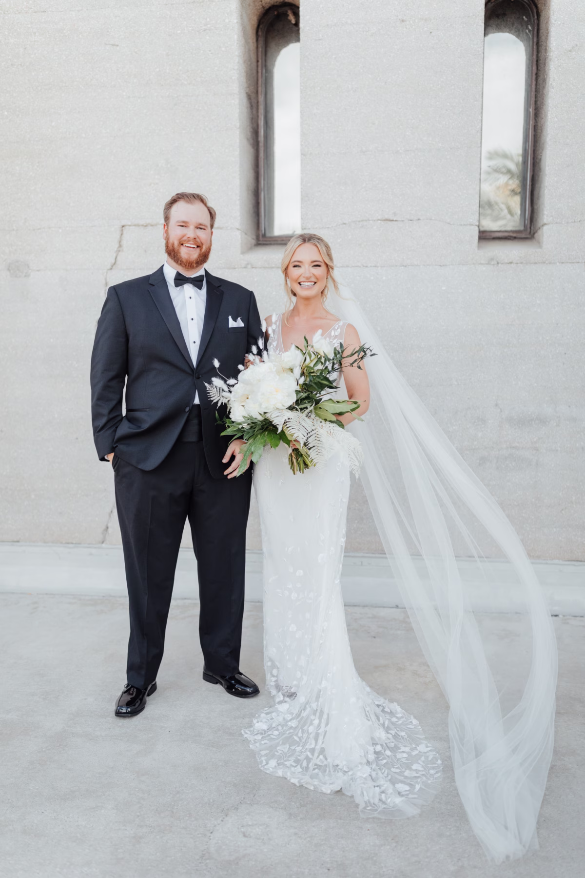 Bride and groom pose for elegant wedding portrait at The Lightner Museum with white bridal bouquet by Aime Peterson Flowers in St Augustine