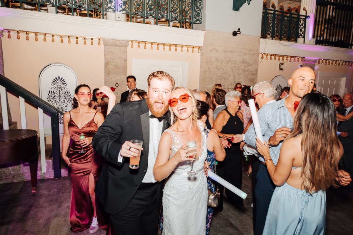 Wedding guests celebrating with bride and groom at historic Lightner Museum reception planned by Coastal Celebrations in St. Augustine