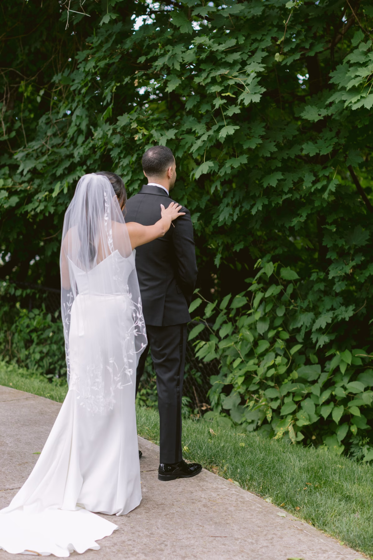 Bride and groom embracing in lush garden setting at The Roundhouse Beacon Hudson Valley wedding venue photographed by Ashley Izquierdo Photography