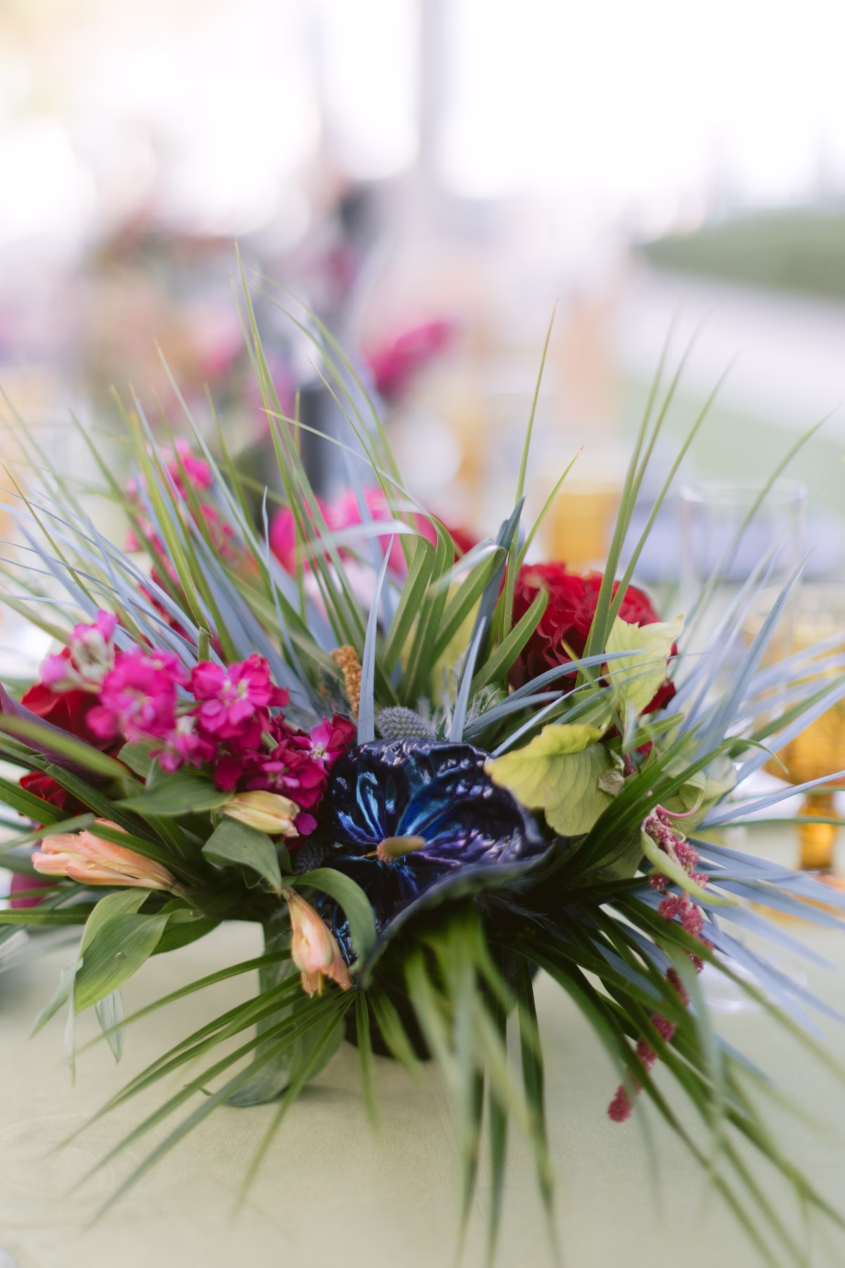 Dramatic jewel tone wedding centerpiece with blue and pink flowers by Arms of Persephone florist at Casa Marina Key West destination wedding photographed by Ashley Izquierdo Photography