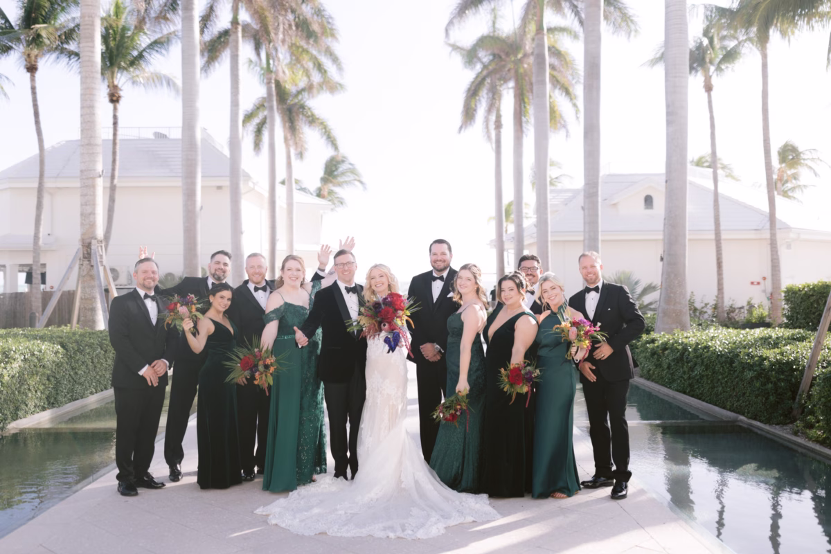 Wedding party in emerald green attire with tropical bouquets by Arms of Persephone at Casa Marina Key West photographed by Ashley Izquierdo Photography