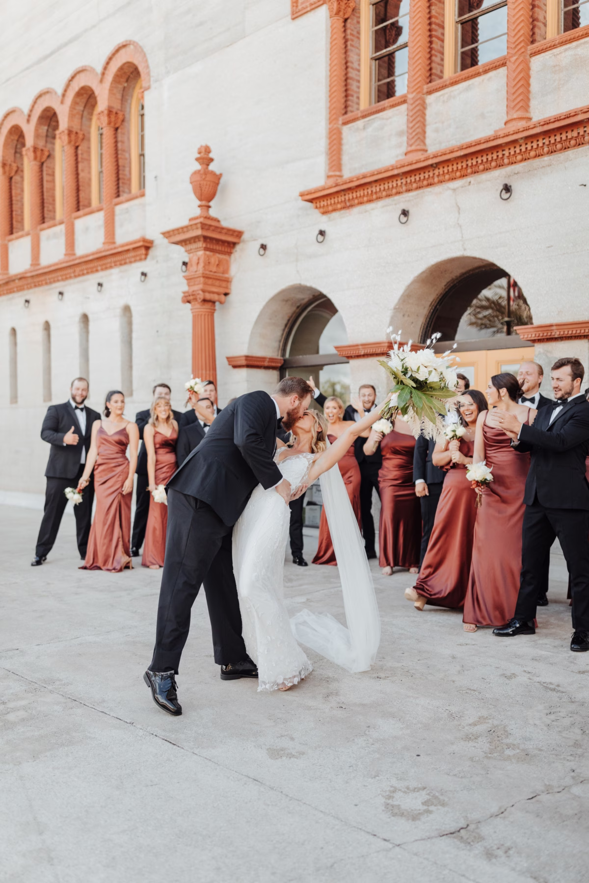 Bride and groom celebrating with wedding party at The Lightner Museum historic venue coordinated by Coastal Celebrations wedding planning