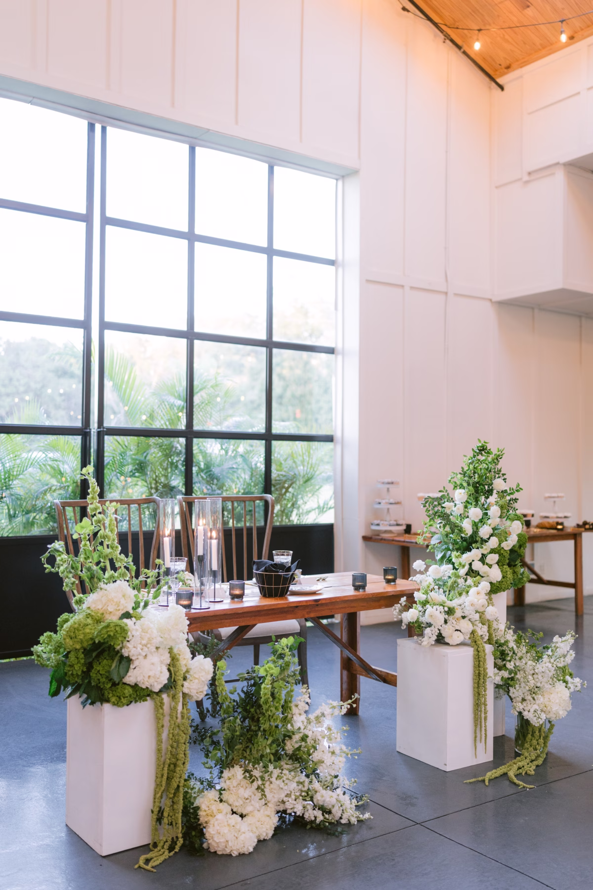 Modern wedding ceremony setup with white floral arrangements by Ava Elise Decor at Soire Estate Tampa featuring clean lines and natural light