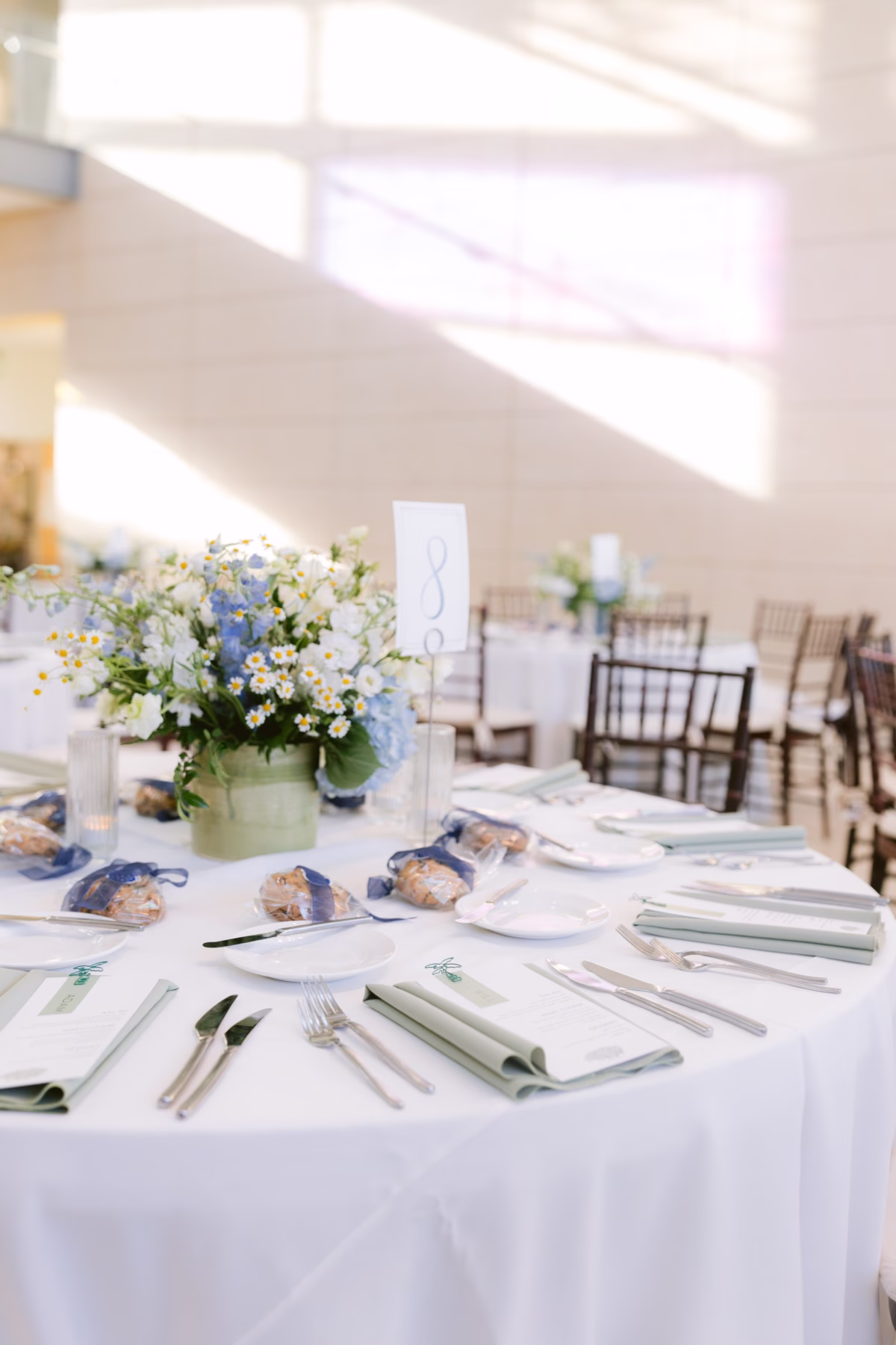 Elegant wedding reception tablescape with white and blue floral centerpiece by Wonderland Floral Art at Nancy Cotto Events venue in St. Petersburg