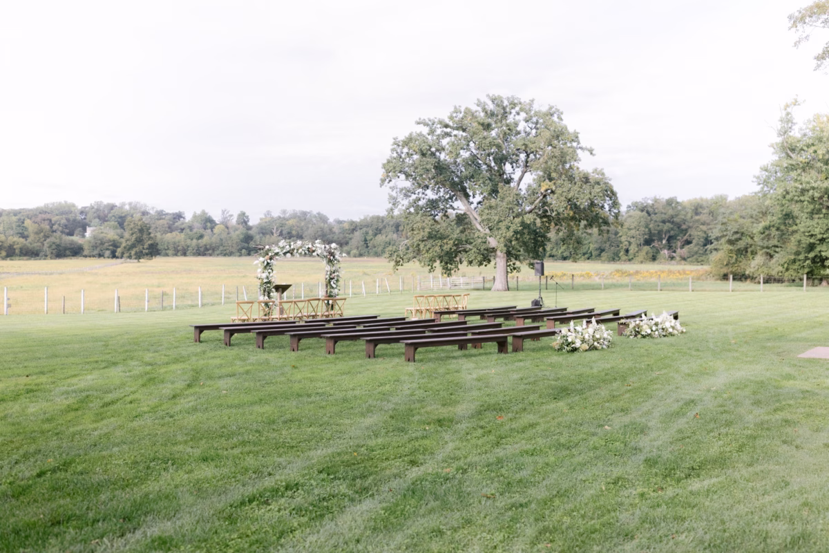 outdoor wedding ceremony johnsons locust hall farm venue - A Farm Wedding at Johnson's Locust Hall, New Jersey Outdoor wedding ceremony setup with wooden benches and floral arch at Johnson's Locust Hall farm venue in New Jersey