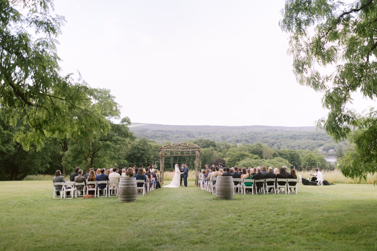 Outdoor wedding ceremony at Red Maple Vineyard with wooden arch and rolling hills captured by Tampa Bay wedding photographer Ashley Izquierdo Photography