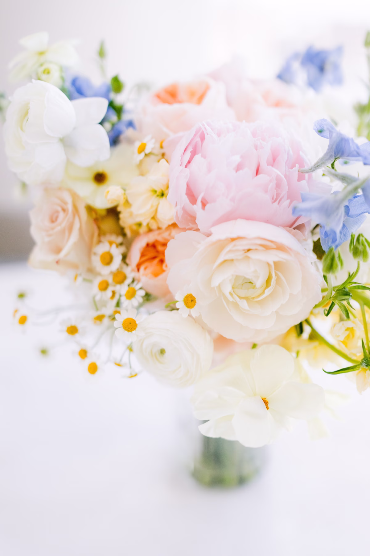 Soft pastel wedding bouquet with white ranunculus, pink roses, and blue flowers by I Dew Events for Tampa Bay wedding at Armature Works photographed by Ashley Izquierdo Photography