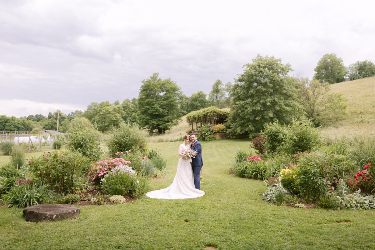 Bride and groom embrace in wildflower garden at Red Maple Vineyard wedding photographed by Ashley Izquierdo Photography