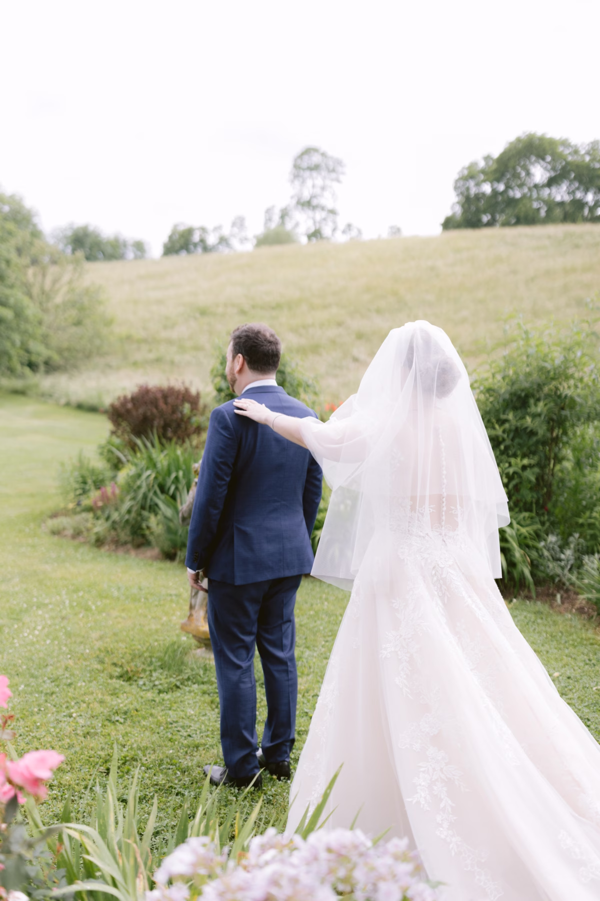 Bride and groom walking through wildflower gardens at Red Maple Vineyard wedding captured by Tampa Bay wedding photographer Ashley Izquierdo Photography