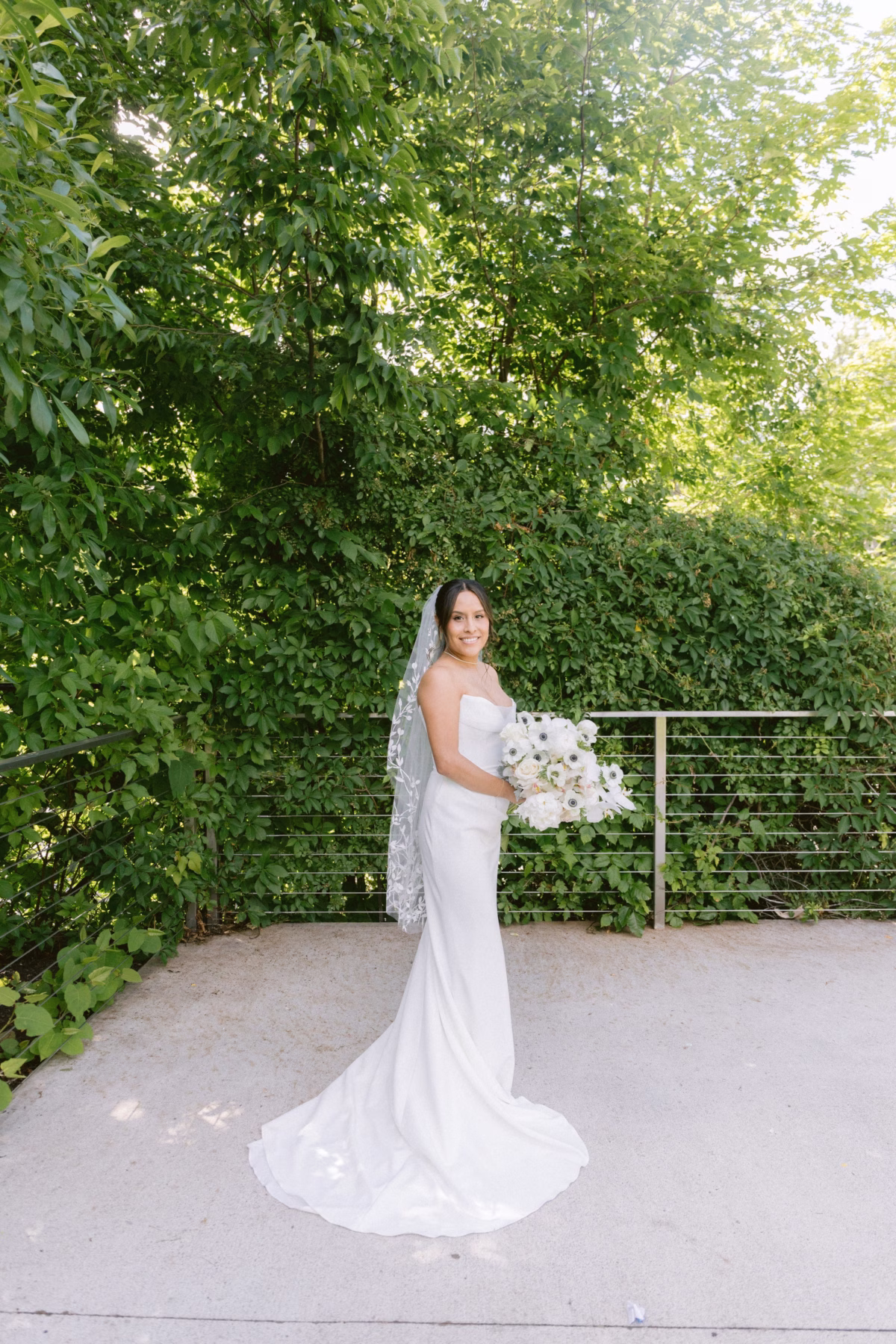 Elegant bride in white gown holding white bouquet by Maky The Diva Flowers at The Roundhouse Beacon Hudson Valley wedding venue