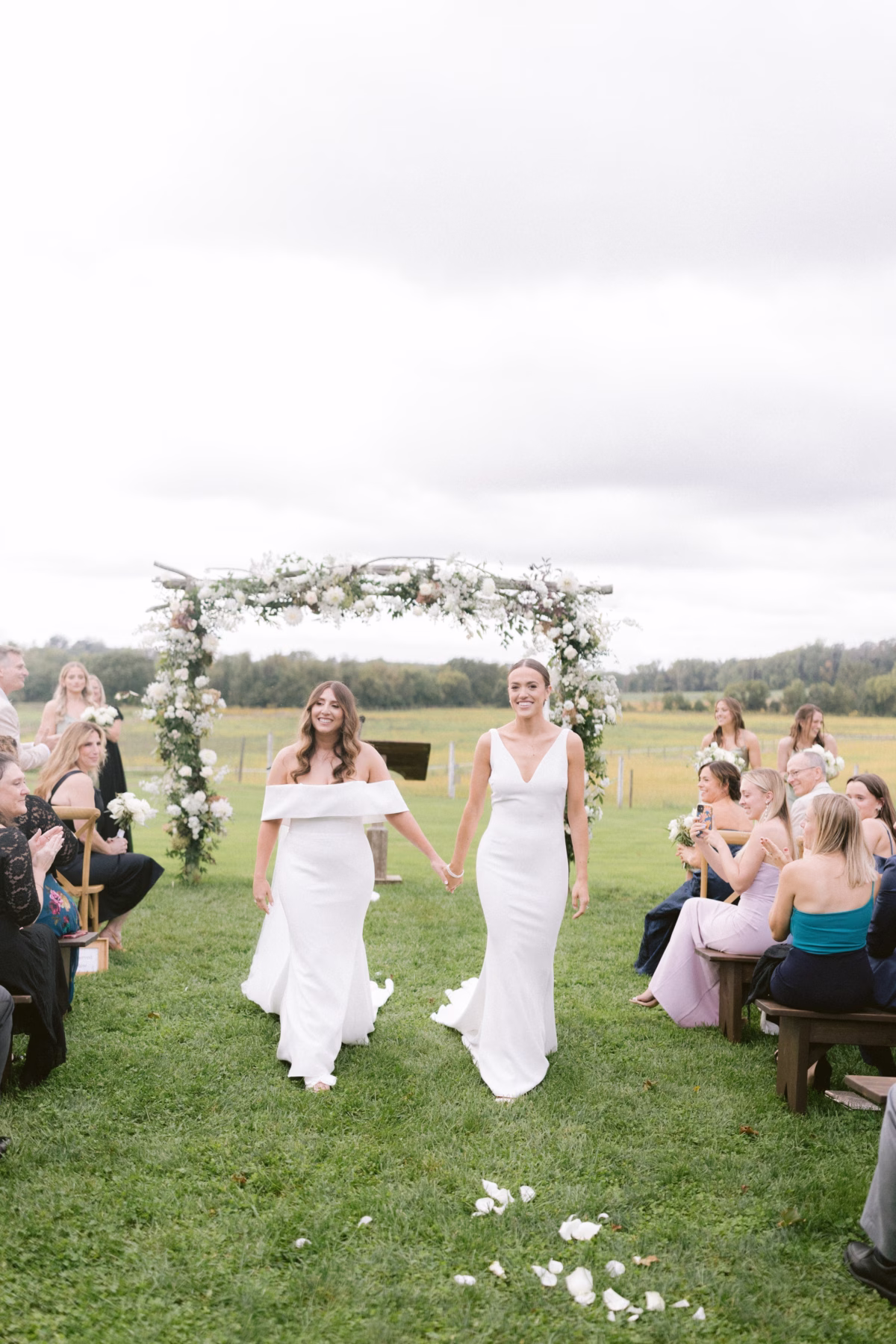 same sex wedding ceremony johnsons locust hall farm new jersey - A Farm Wedding at Johnson's Locust Hall, New Jersey Two brides in white dresses walking down the aisle after their outdoor farm wedding ceremony at Johnson's Locust Hall in New Jersey with floral arch by Allie Johnson and planning by Olive and Shae