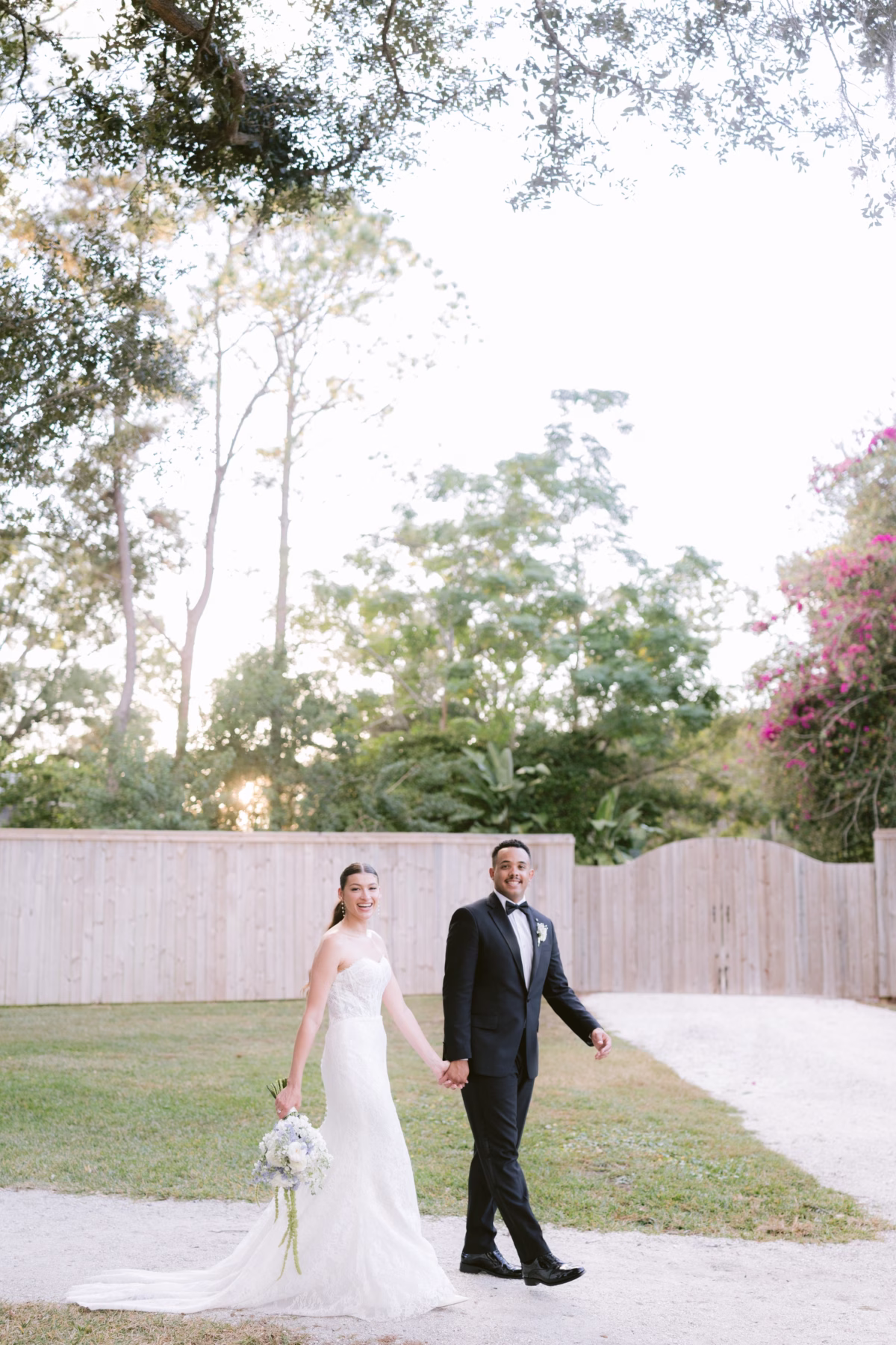 Bride and groom walking hand in hand at Soire Estate Tampa wedding, bride wearing Ella Blu Bridal dress photographed by Ashley Izquierdo Photography