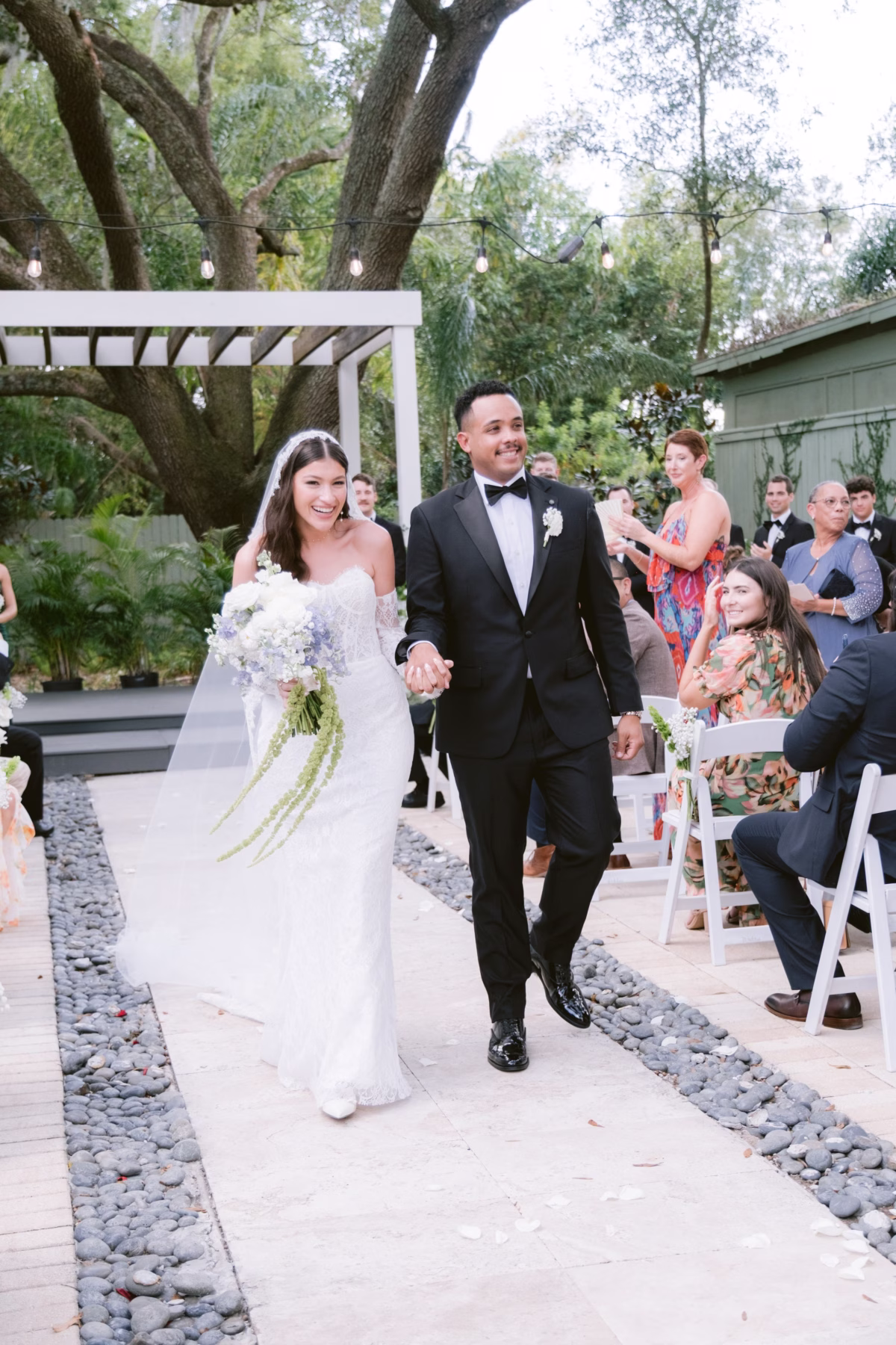 Newlyweds walk down the aisle after their wedding ceremony at Soire Estate in Tampa, planned by Daniela Alvarez Event Planning