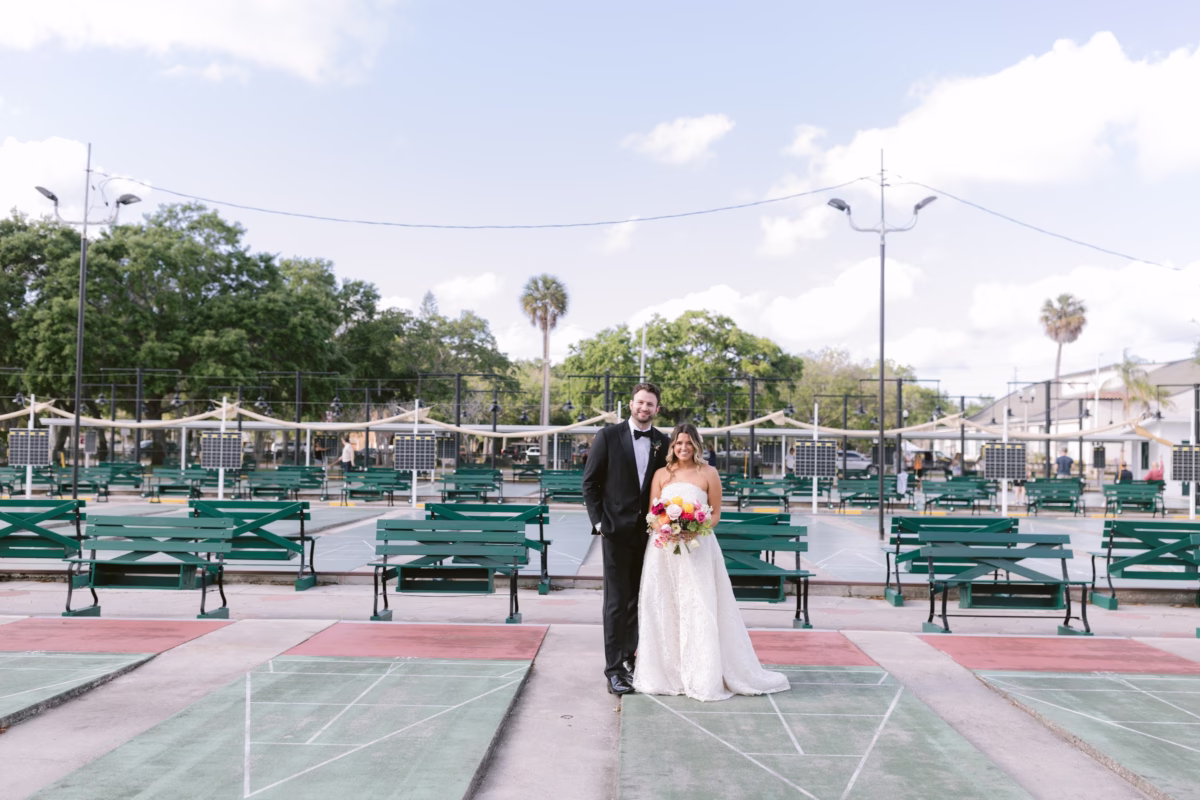 Bride and groom portrait at St Pete Shuffleboard Club wedding with colorful bouquet by Petite Fleur and planning by Day of Details