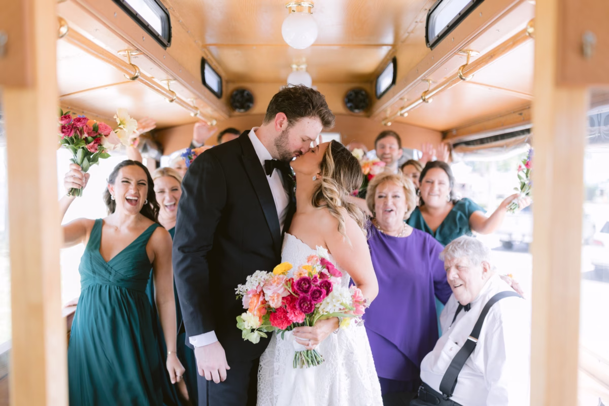Bride and groom share intimate moment during wedding ceremony at St Pete Shuffleboard Club with colorful Petite Fleur bouquet surrounded by family and friends