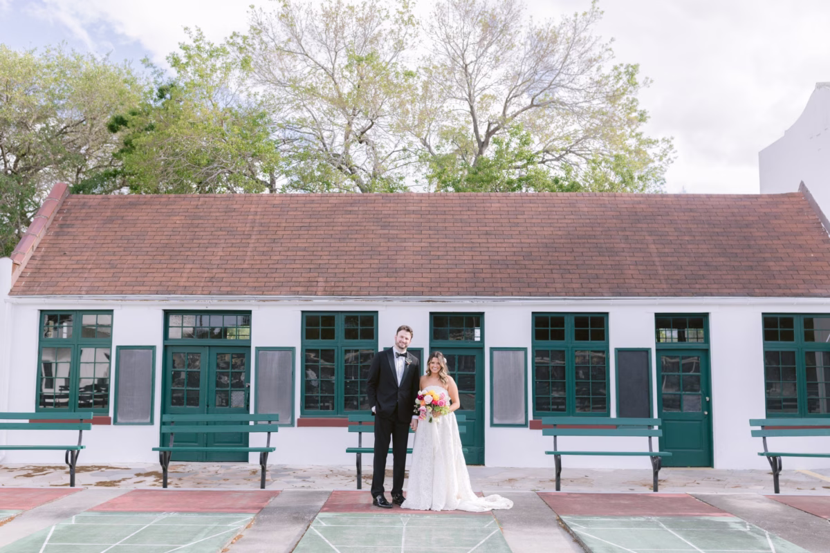Bride and groom portrait at St. Pete Shuffleboard Club with historic white building backdrop, coordinated by Day of Details wedding planning