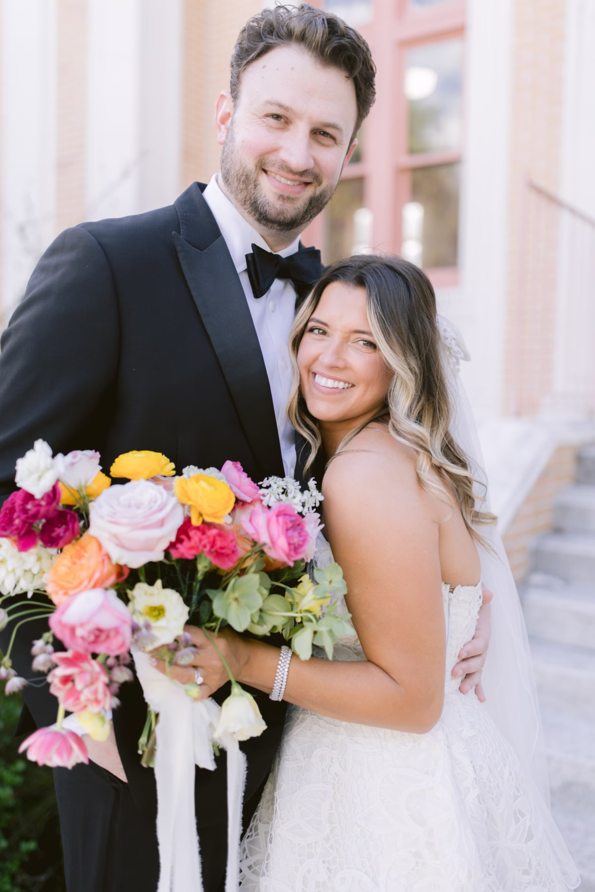 Bride and groom wedding portrait with colorful bridal bouquet by Petite Fleur at St Pete Shuffleboard Club captured by Tampa Bay wedding photographer Ashley Izquierdo Photography