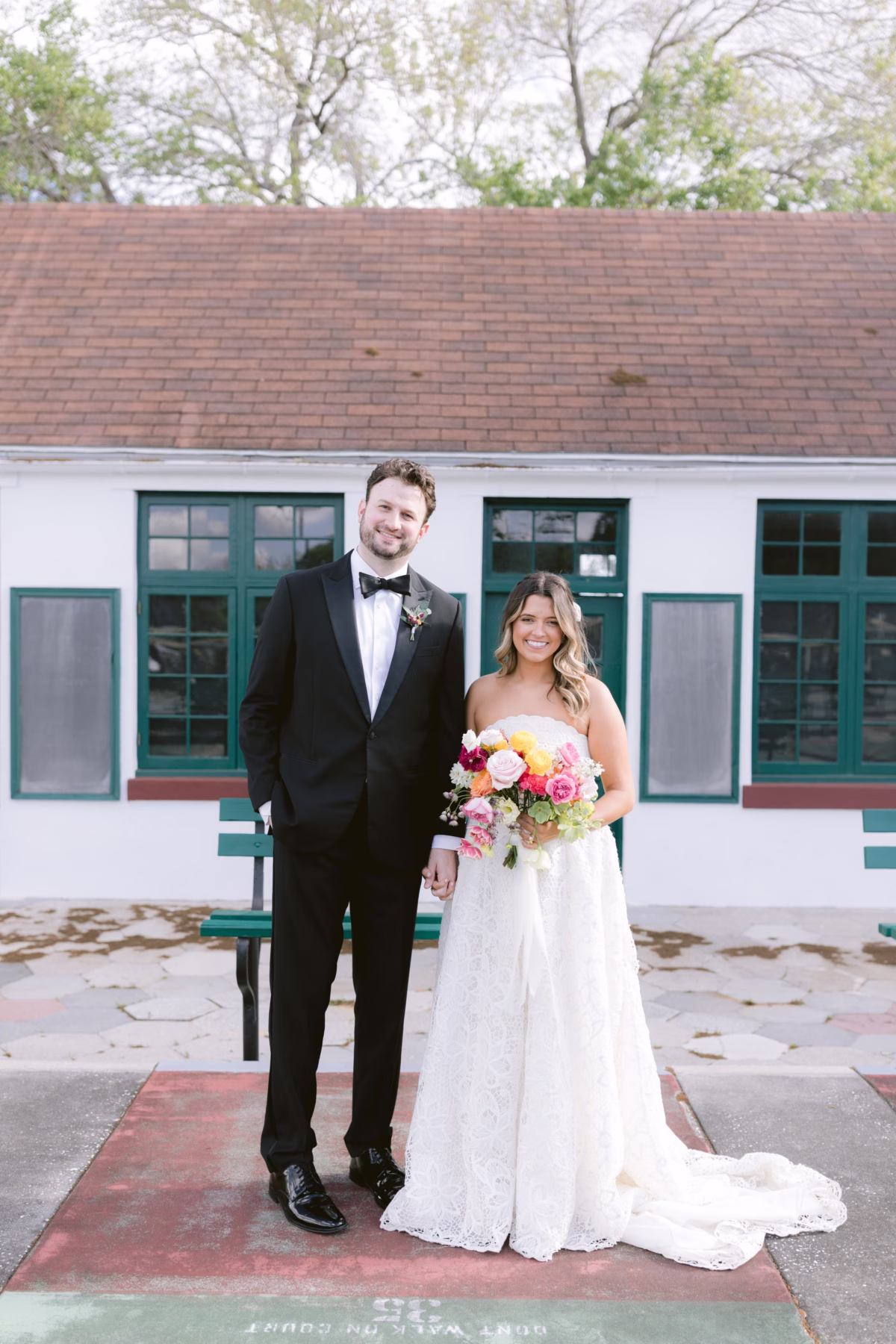 Bride and groom portrait with colorful bouquet by Petite Fleur at St Pete Shuffleboard Club wedding coordinated by Day of Details