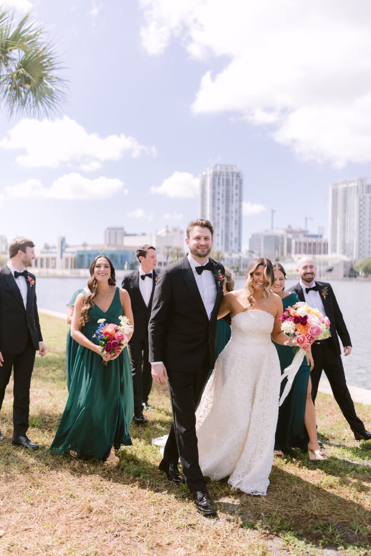 Wedding party with emerald bridesmaid dresses and colorful bouquets by Petite Fleur at St. Pete Shuffleboard Club captured by Ashley Izquierdo Photography