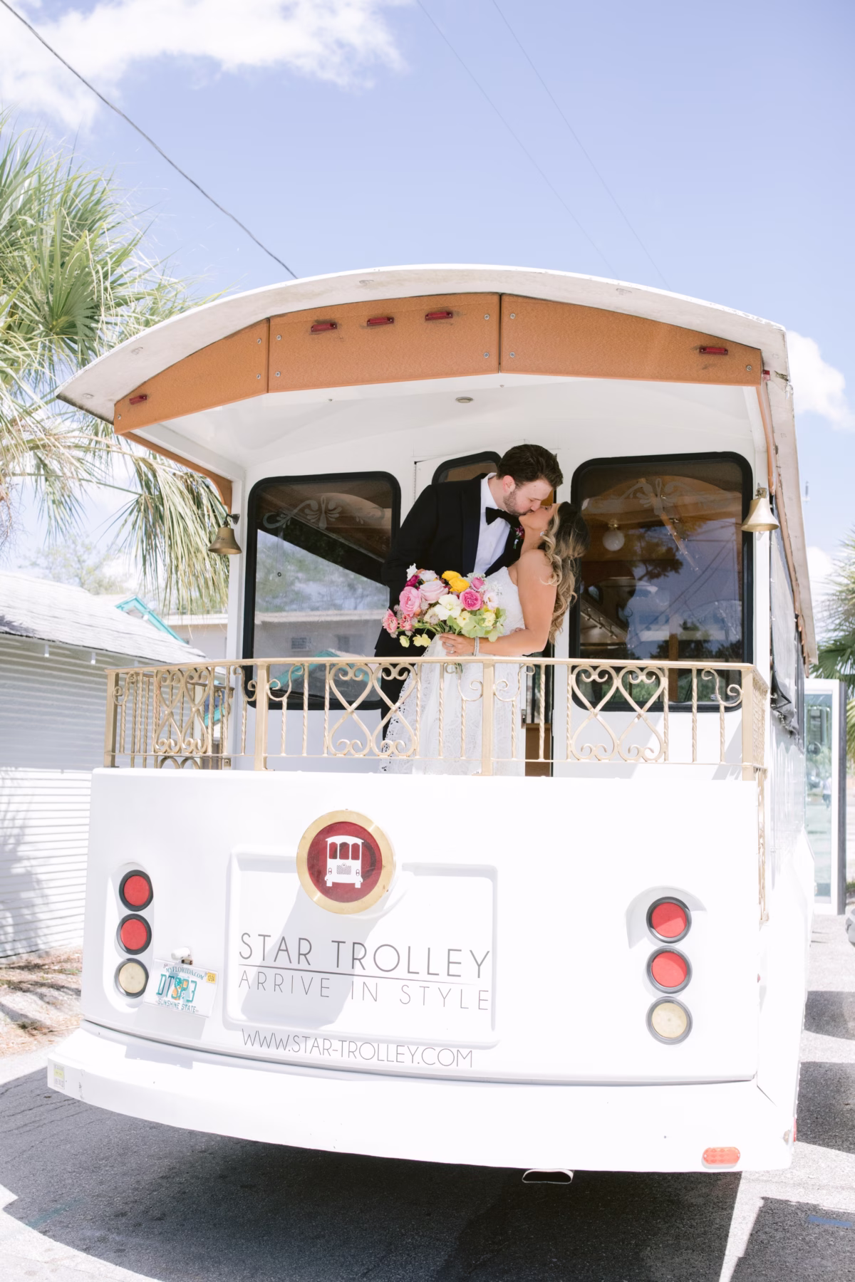 Bride and groom kiss on Star Trolley at St Pete Shuffleboard Club wedding coordinated by Day of Details in Tampa Bay