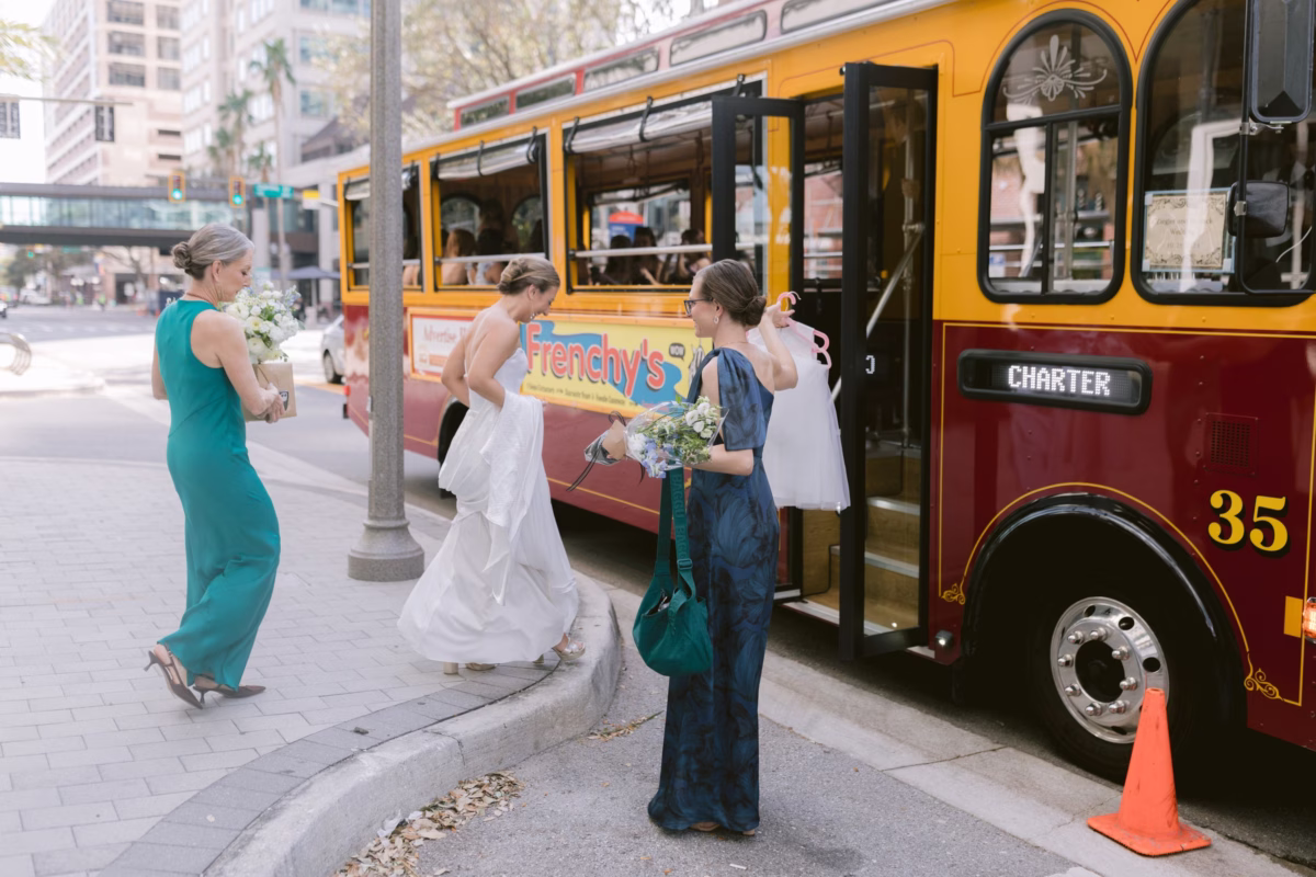 Wedding party boarding vintage trolley with bridal bouquet by Wonderland Floral Art in St. Petersburg