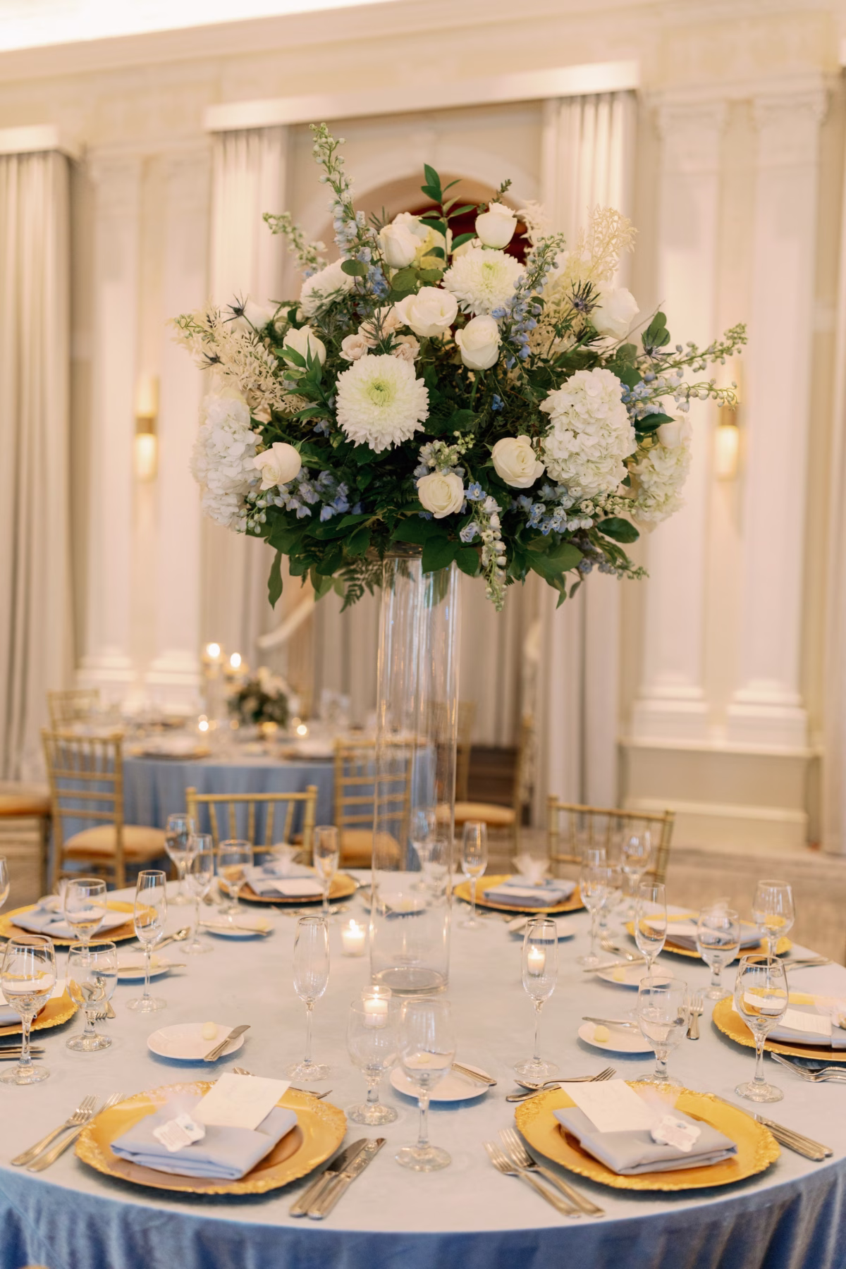 Elegant tall floral centerpiece with white flowers and blue accents by Lemon Drops Weddings and Events at The Vinoy St. Petersburg wedding reception