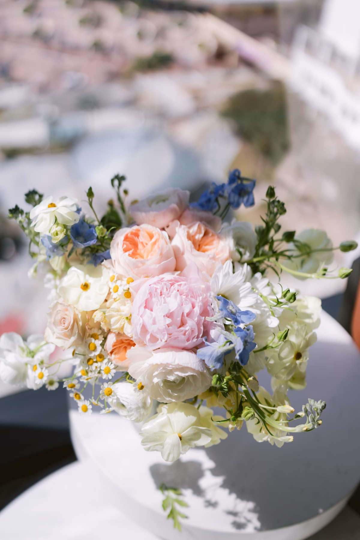 Romantic bridal bouquet with peach roses, pink peonies, white daisies and blue delphiniums created by I Dew Events for Armature Works Tampa wedding