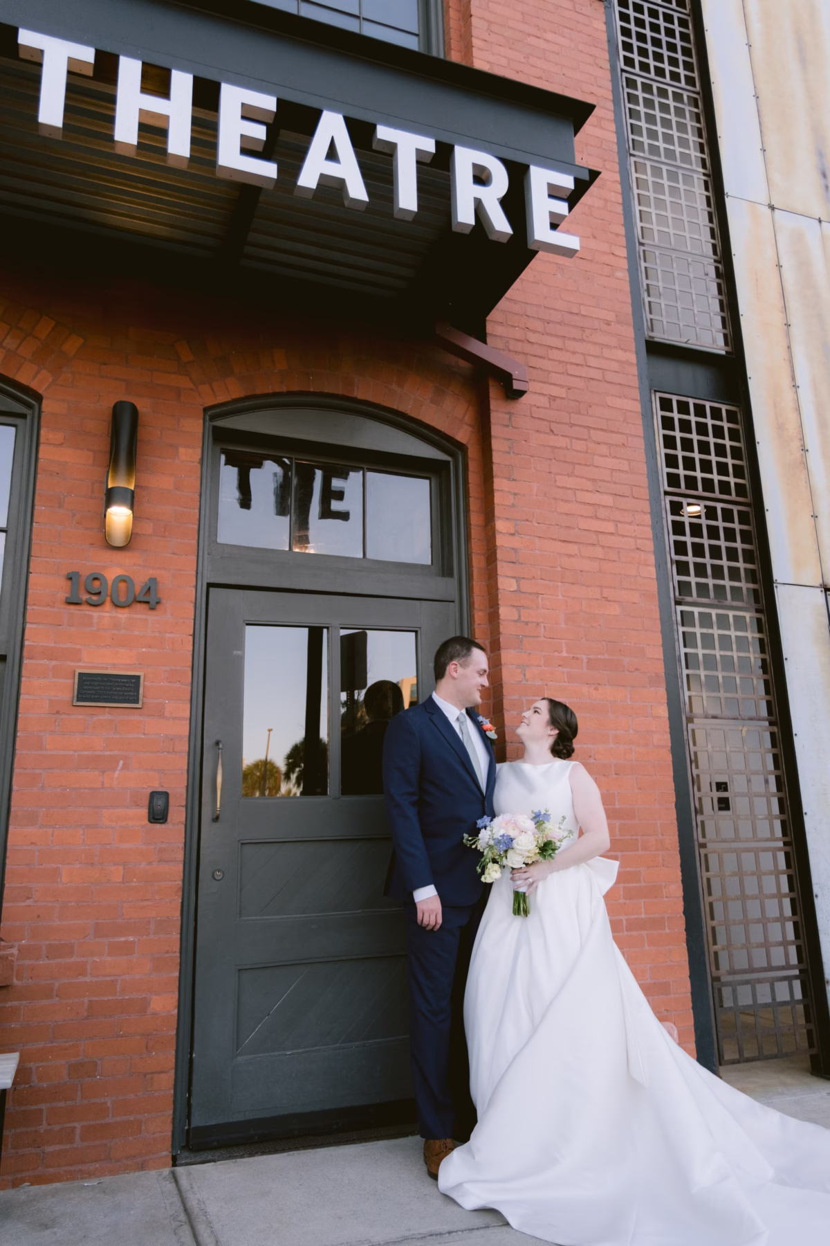 Bride and groom wedding portrait at Armature Works Theatre in Tampa with bridal bouquet by I Dew Events florist