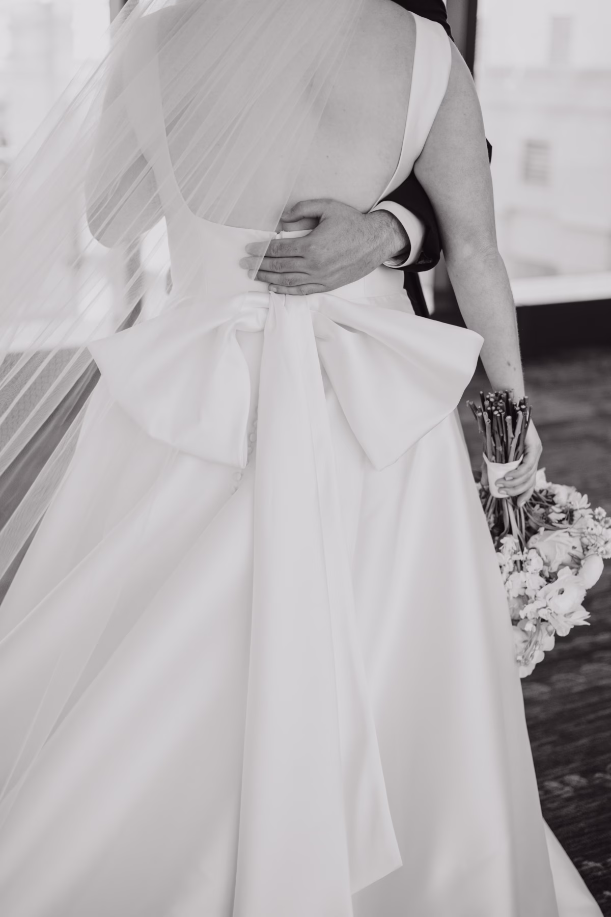 Elegant black and white bridal portrait showcasing The White Closet Bridal wedding gown with flowing veil and I Dew Events floral bouquet at Armature Works Tampa wedding