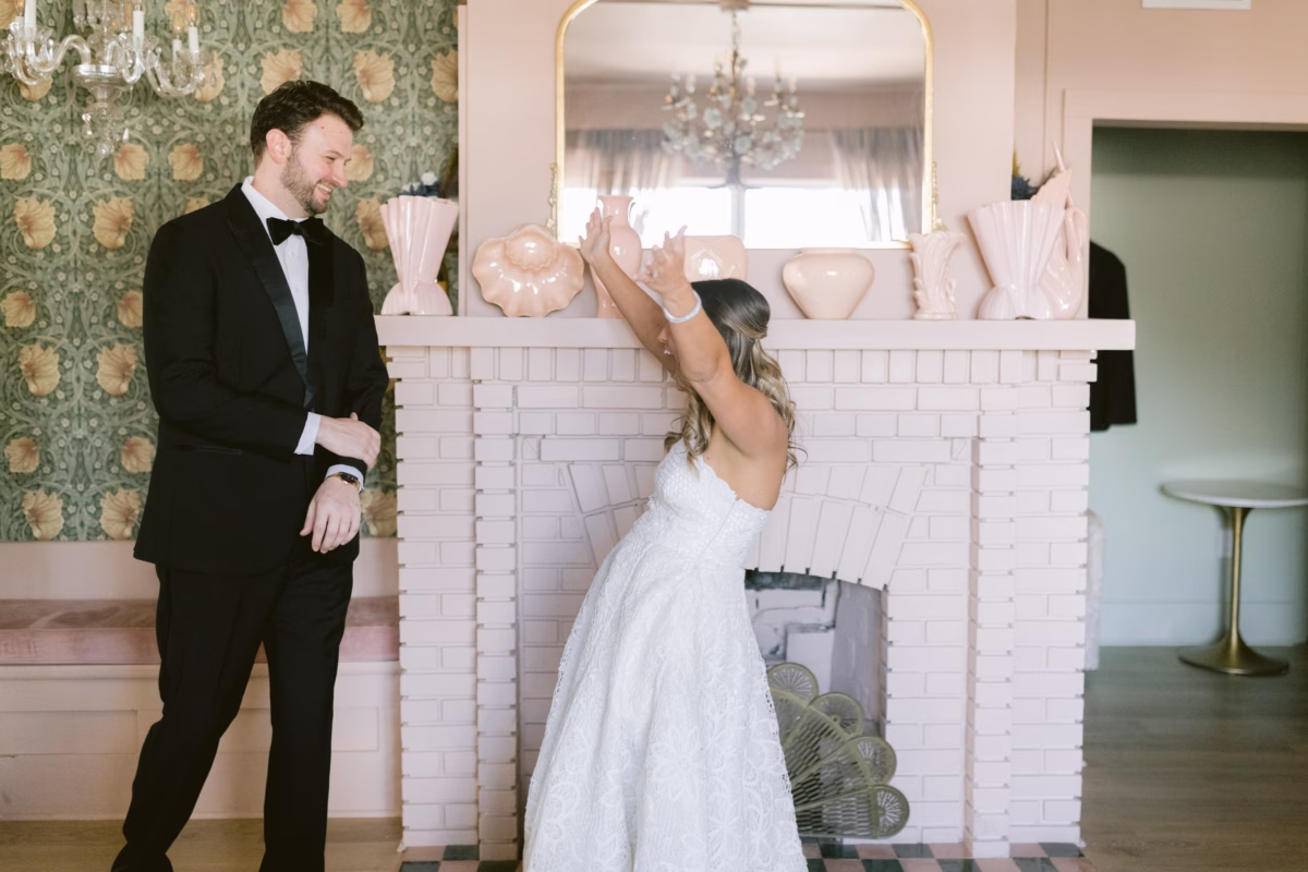 Bride and groom's first look moment at Hostess House captured by Tampa Bay wedding photographer Ashley Izquierdo Photography with bride in BHLDN wedding dress and groom in The Black Tux