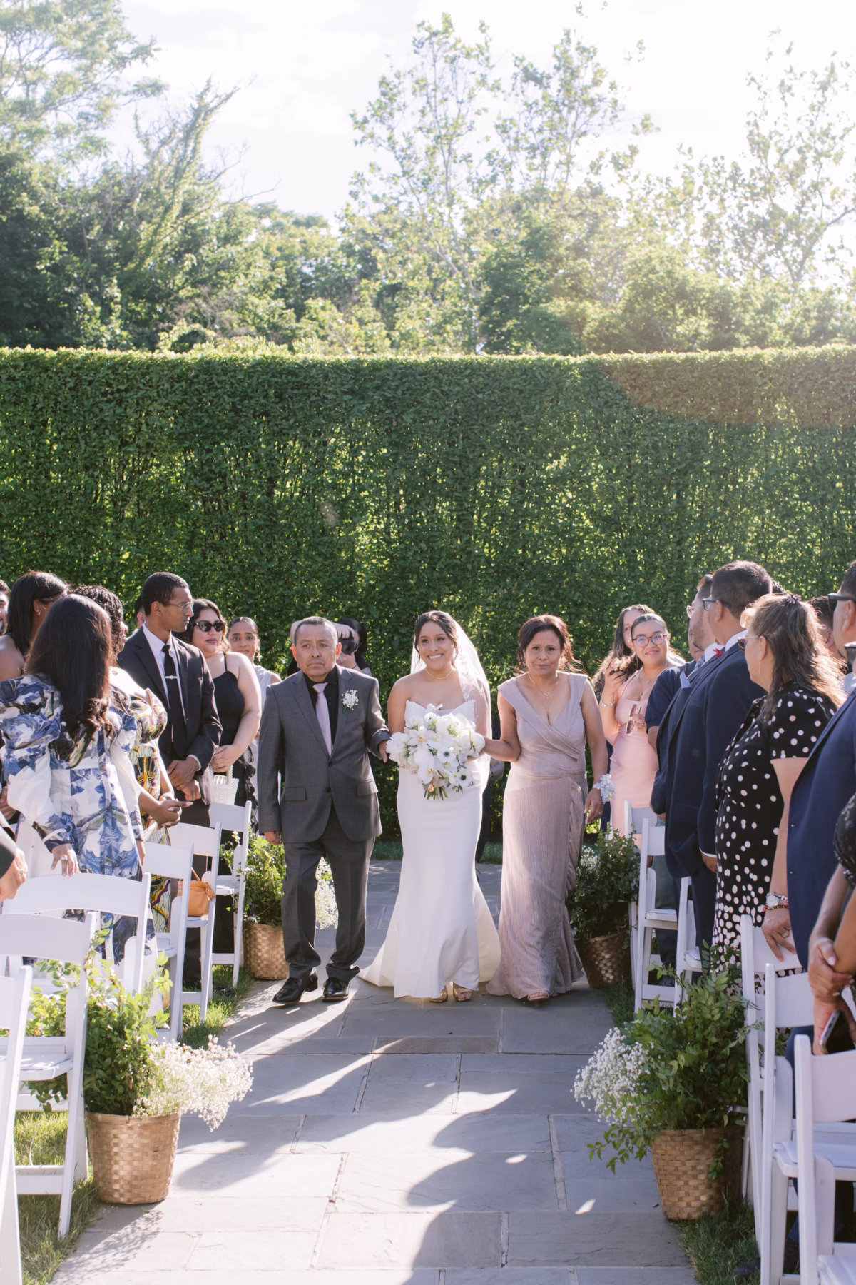 Bride walking down the aisle with floral arrangements by Maky The Diva Flowers at The Roundhouse Beacon wedding ceremony in Hudson Valley