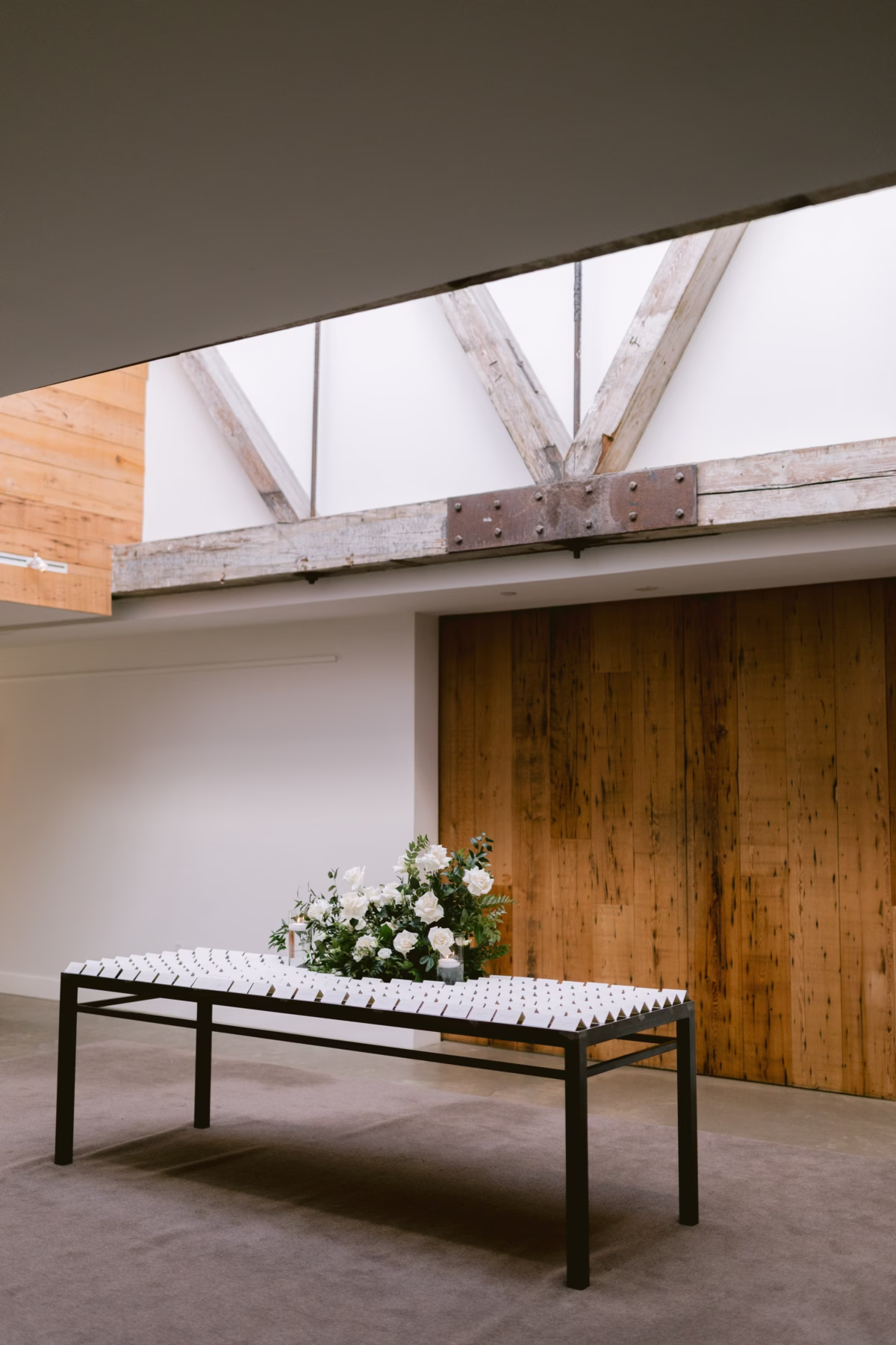 Wedding escort card table with white rose arrangement by Maky The Diva Flowers at The Roundhouse Beacon Hudson Valley venue