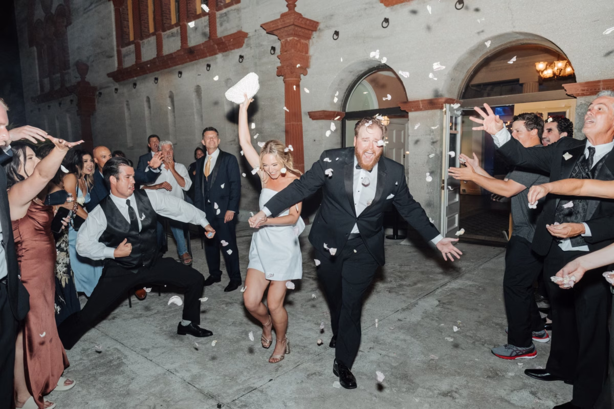 Bride and groom run through confetti toss exit at The Lightner Museum wedding planned by Coastal Celebrations in St Augustine