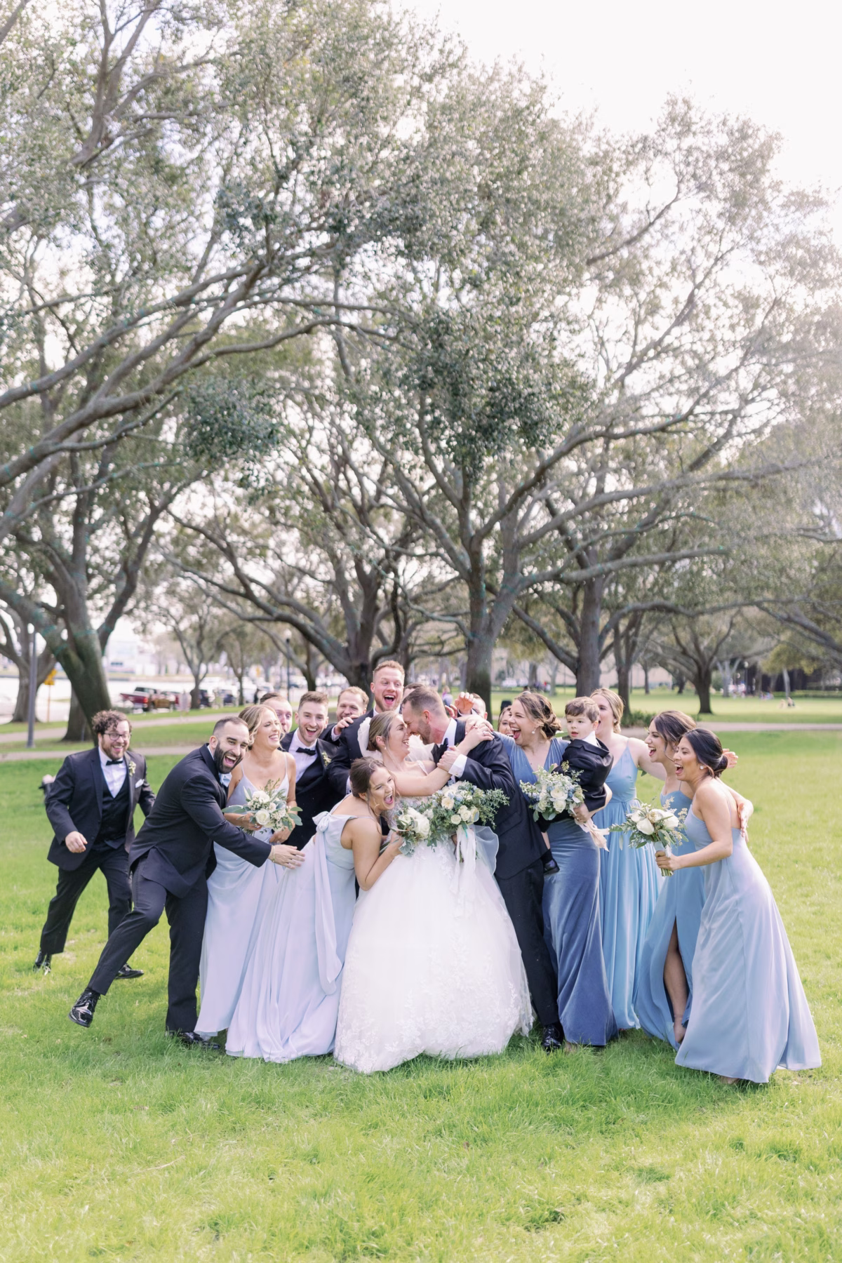 Wedding party group photo with blue bridesmaid dresses and white florals by Lemon Drops Weddings and Events at The Vinoy St. Petersburg
