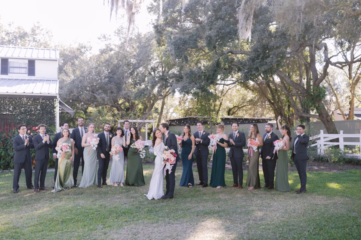 Large wedding party portraits with coral and pink bouquets by Golden Wild Florals at Soire Estate garden wedding in Tampa