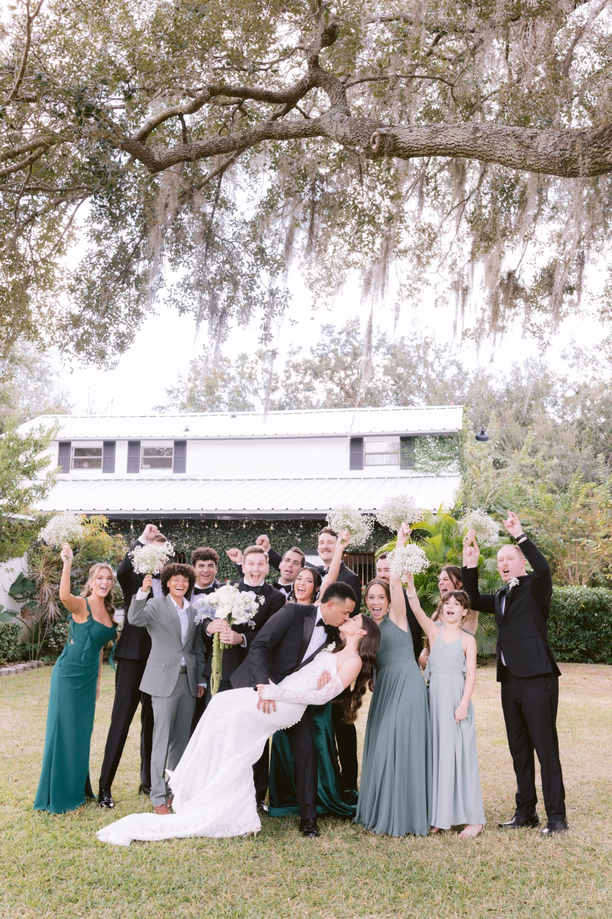 Joyful wedding party group portrait with bride and groom at Soire Estate Tampa planned by Daniela Alvarez Event Planning