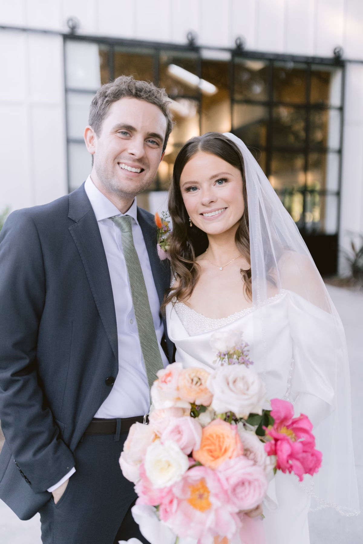 Bride and groom wedding portrait with colorful bridal bouquet by Golden Wild Florals at Soire Estate Tampa garden wedding