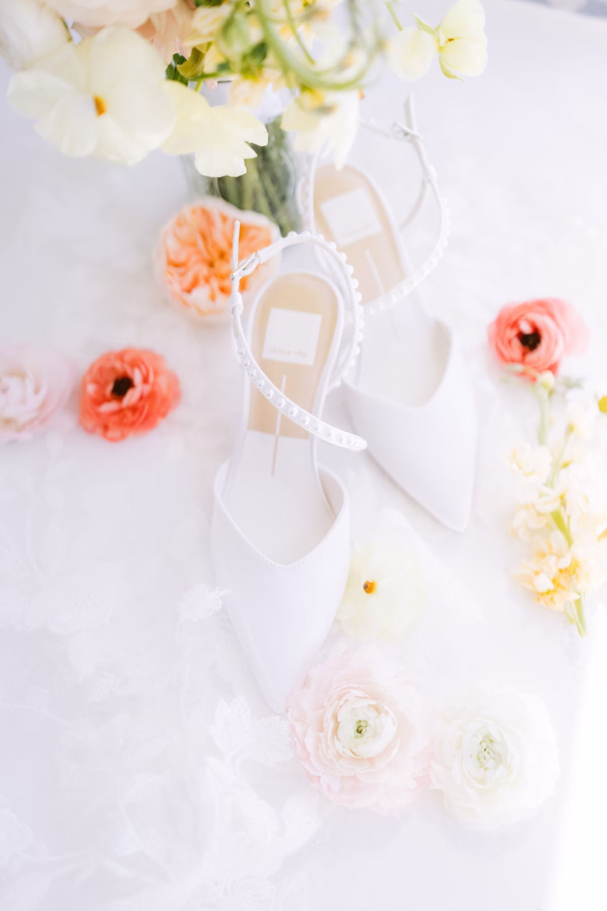 Elegant white ribbon and coral ranunculus wedding detail flatlay by I Dew Events florist at Armature Works Tampa wedding photographed by Ashley Izquierdo Photography