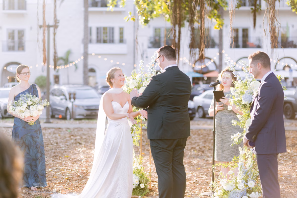 Outdoor wedding ceremony at St. Petersburg art museum with floral ceremony backdrop by Wonderland Floral Art photographed by Ashley Izquierdo Photography