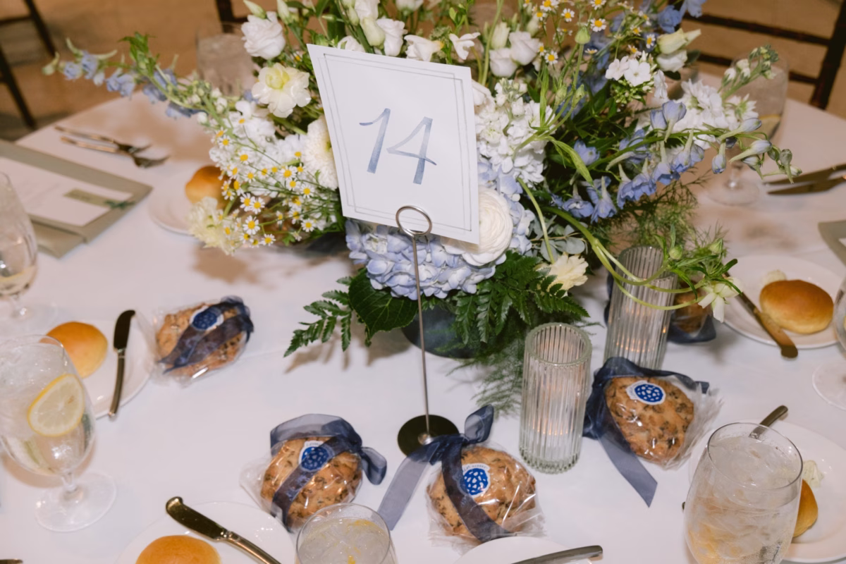Elegant wedding reception centerpiece by Wonderland Floral Art featuring blue hydrangeas and white flowers with table number fourteen at Nancy Cotto Events venue in St. Petersburg